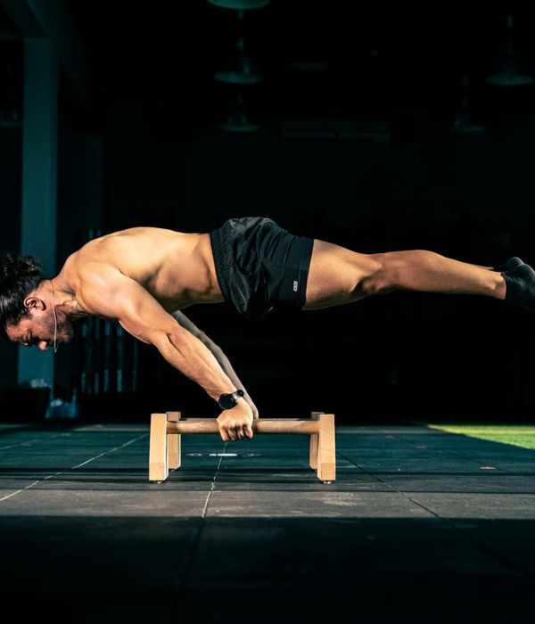 Man performing a controlled strength exercise in a modern gym setting.